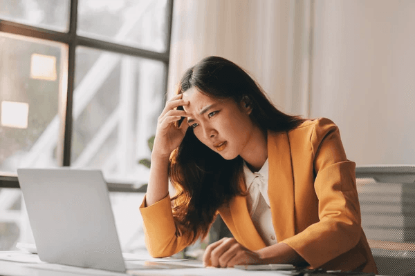 Kyriba consultant stressed while reviewing bank connectivity issues on her laptop